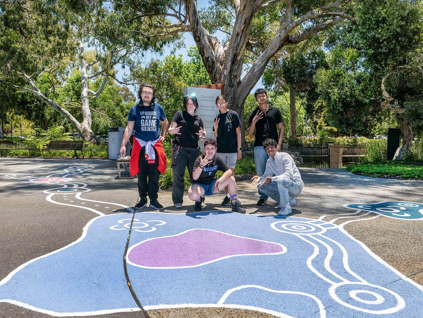 Group of 6 young people standing on top of street art painted onto the floor as part of a placemaking project