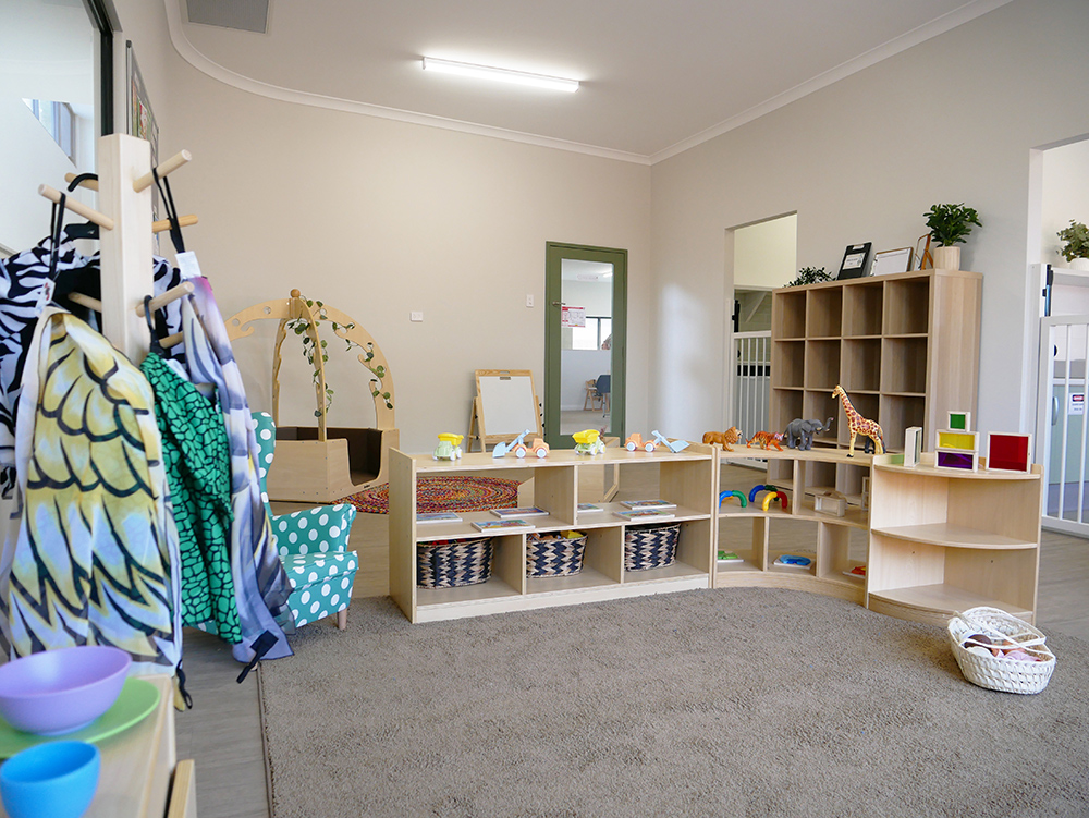 Spacious infant room with organised toy storage and natural learning materials at Brabham childcare