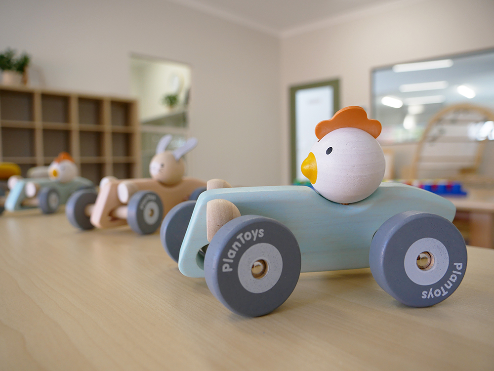 Wooden toy cars with animal figures in a bright childcare playroom at Brabham childcare centre
