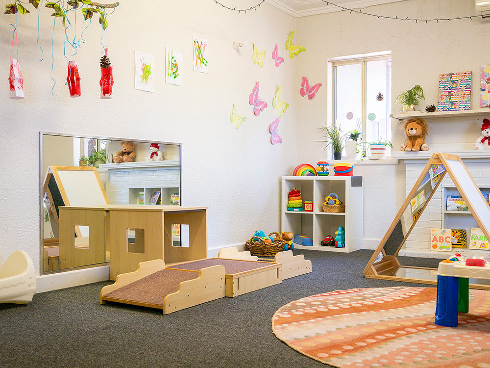 Nursery space with age-appropriate toys and children's artwork at East Cannington