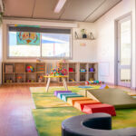 Bright infant room with soft play equipment and developmental toys at Newman childcare centre