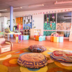 Vibrant learning space with Indigenous-inspired floor cushions and nature murals at Newman childcare centre