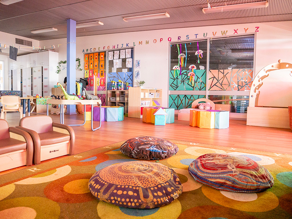 Vibrant learning space with Indigenous-inspired floor cushions and nature murals at Newman childcare centre