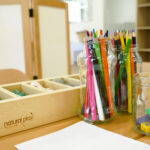 Colouring in pencils, paper and craft supplies on table at Port Hedland Early Learning Centre