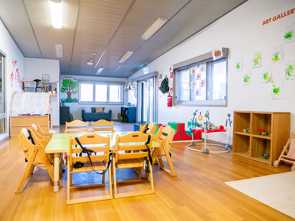 Large room with a couch, activity stations and age-appropriate toys at Port Hedland Early Learning Centre