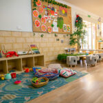 Childrens play area with toys, cushions and books at Westminster Early Learning Centre