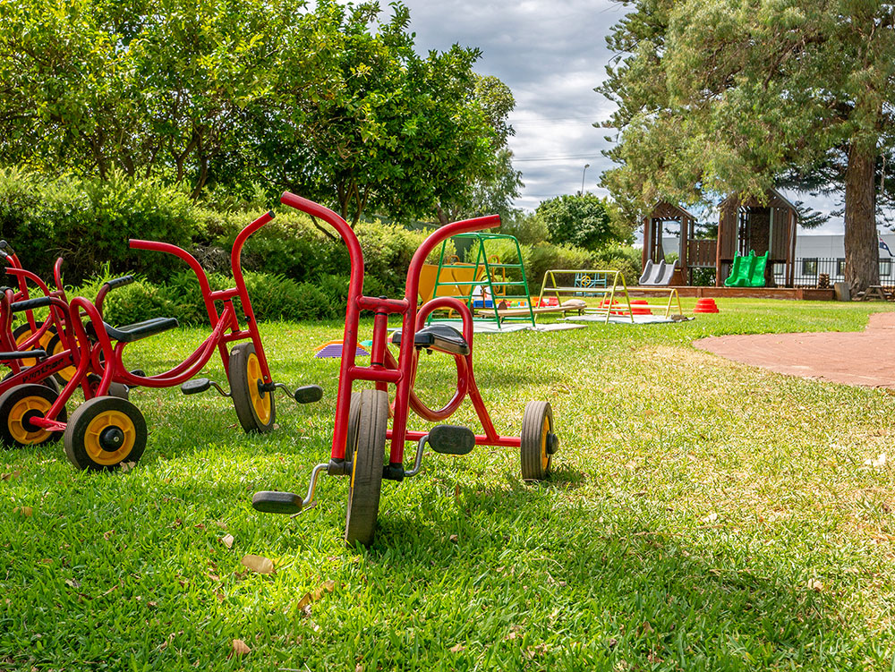 Outside play area with bikes, playground and play equipment at Yappara House Early Learning Centre