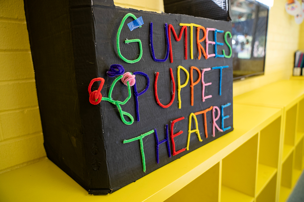 Handmade cardboard puppet theater with 'Gumtrees Puppet Theatre' in colorful pipe cleaner letters