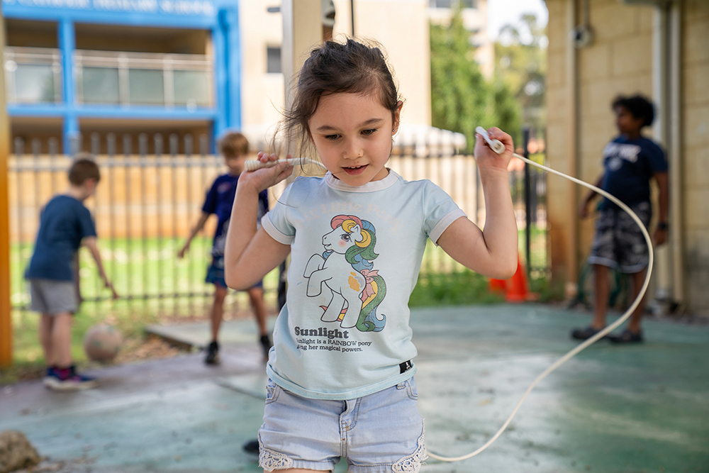 Child skipping outside during Gumtrees OSHC School Holiday Program