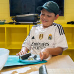 Child arranging homemade sushi on plate during cooking activity at Gumtrees OSHC School Holiday Program