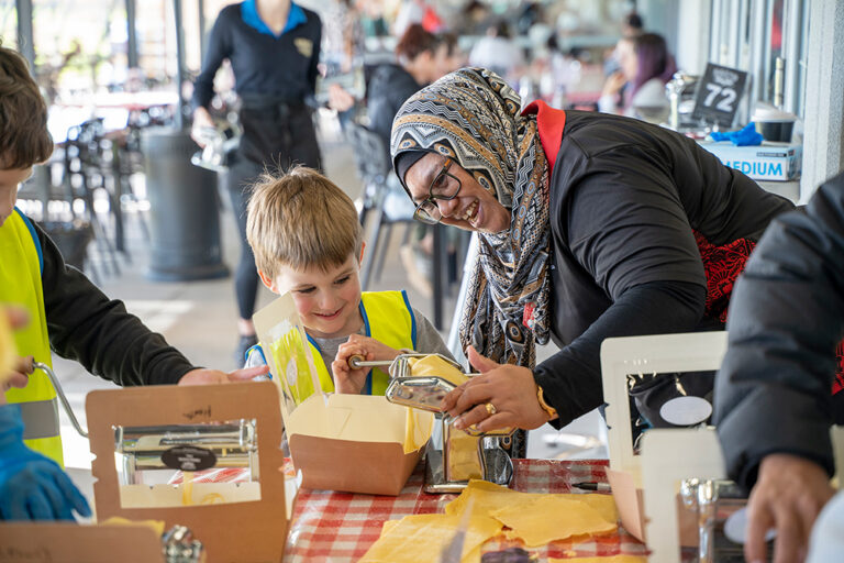 Child and OSHC Supervisor Ennity Lumsden making pasta together at Huntingdale OSHC School Holiday Program
