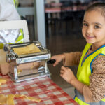 Child making pasta at Huntingdale OSHC School Holiday Program