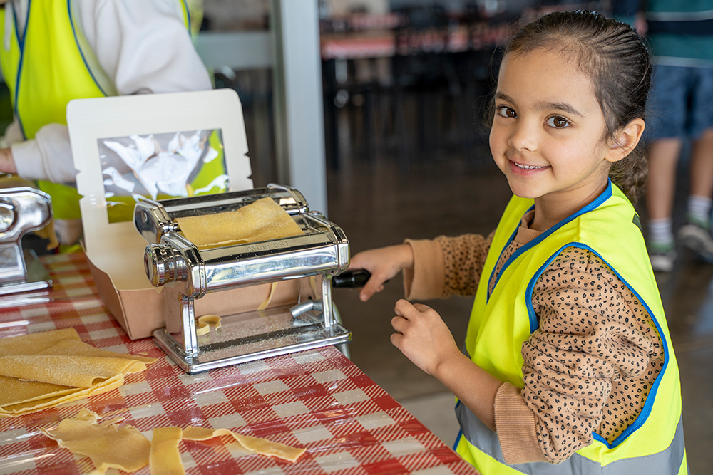 Child making pasta at Huntingdale OSHC School Holiday Program