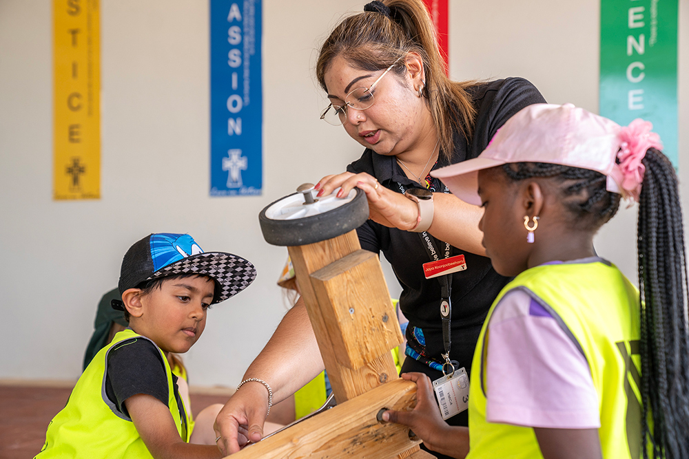 Children and educator collaborating on a go-kart project during Mercy OSHC School Holiday Program