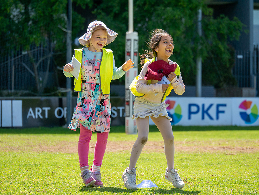 Two children laughing together during Coles Healthy Kicks sports activity at St Denis OSHC School Holiday Program