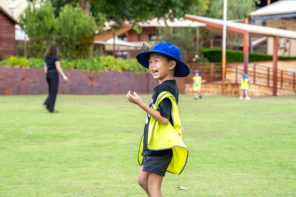 Child playing on the oval at Sacred Heart OSHC School Holiday Program