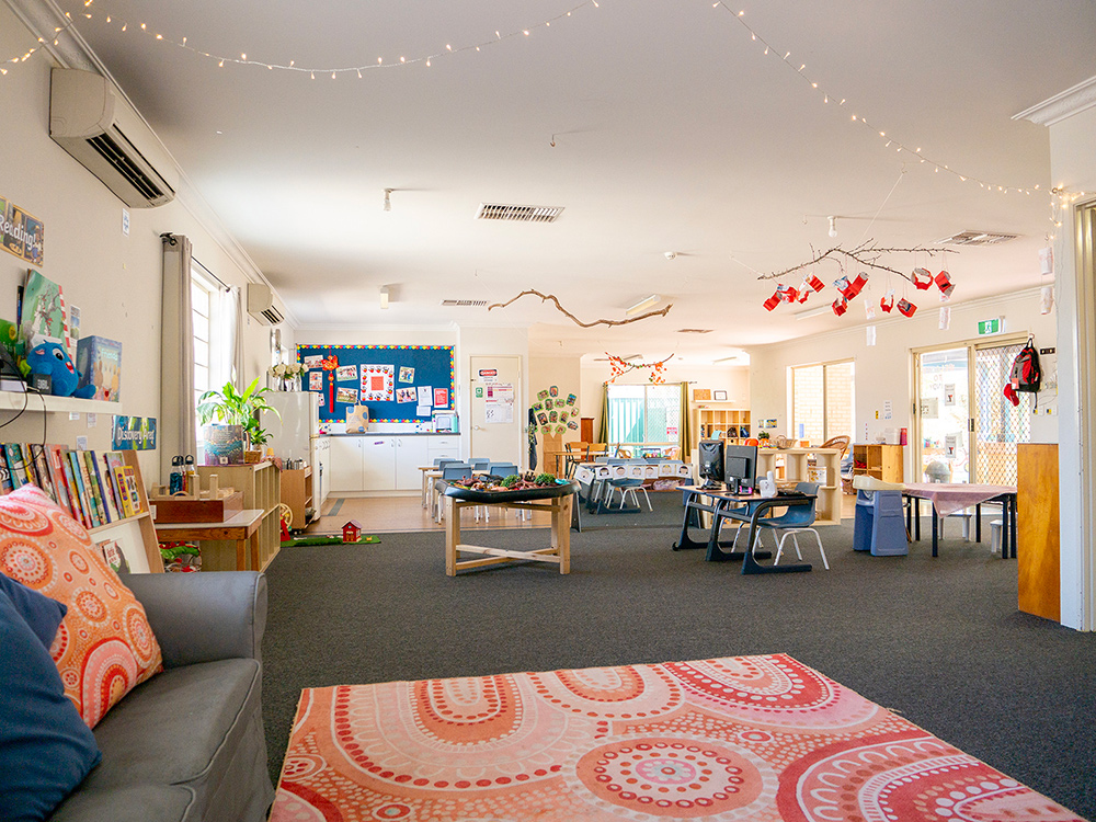 Spacious learning room with activity stations and Indigenous art rug at East Cannington childcare