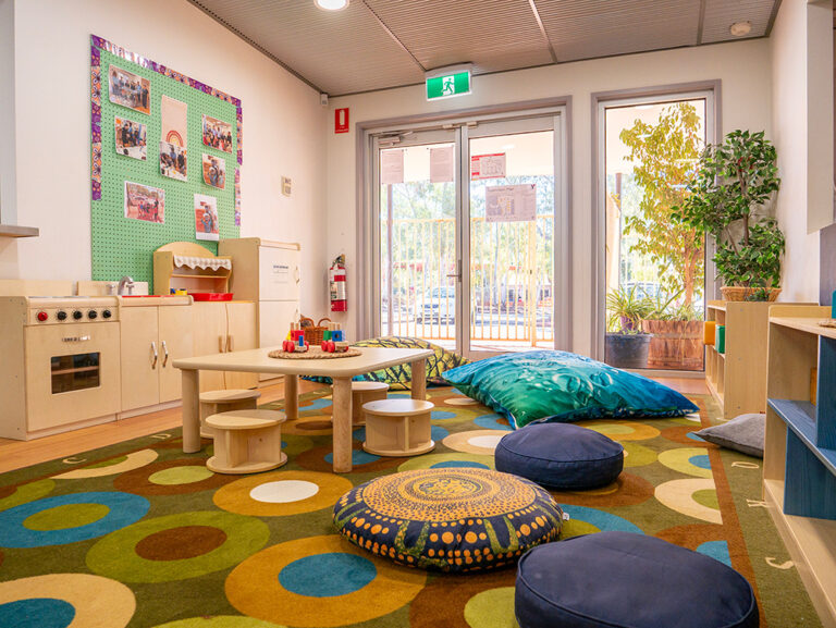Play space with child kitchen area and nature elements at Newman childcare centre