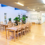 Spacious dining area with timber tables and indoor plants at Port Hedland childcare centre