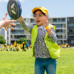 Child passing football during Coles Healthy Kicks activity at Currambine OSHC School Holiday Program