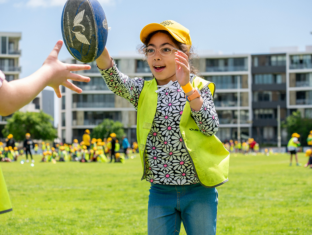 Child passing football during Coles Healthy Kicks activity at Fremantle OSHC School Holiday Program