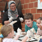 Children and OSHC Supervisor Ennity Lumsden engaging in cooking activity at Huntingdale OSHC School Holiday Program