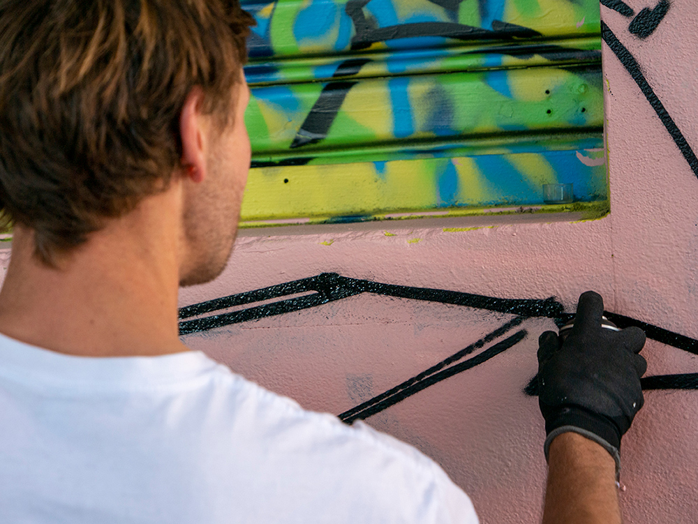 Close up of street artist painting a mural with spray paint