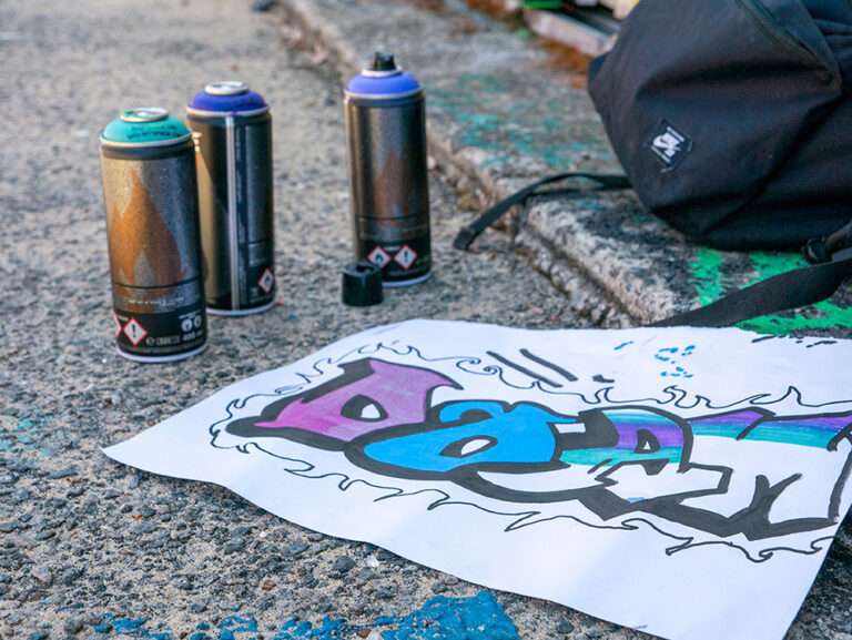 Close up of art and spray paint cans on the ground