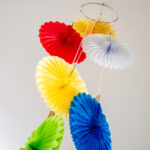 Colorful paper fan mobile decoration in red, yellow, white, blue and green hanging in OSHC room