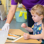 OSHC educator and child making sushi together during cooking activity at Gumtrees OSHC