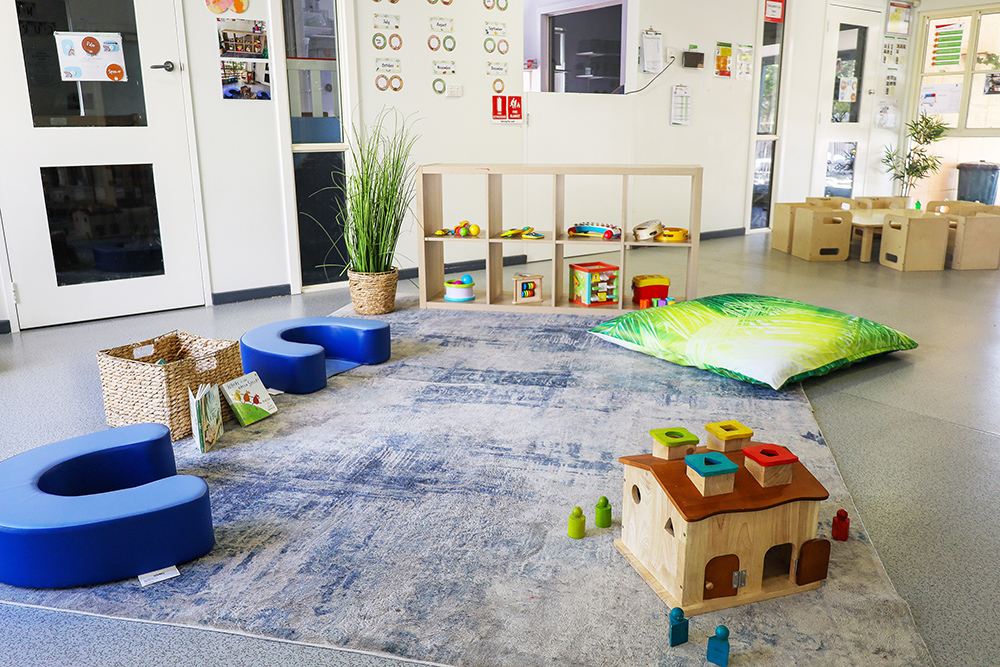 Childrens play area with carpet, pillows, blocks and books