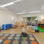 Large childrens play room with carpet, furniture and toys