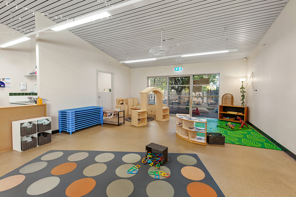 Large childrens play room with carpet, furniture and toys