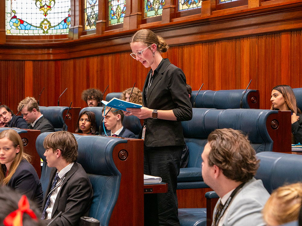 Young person reading from notebook while giving speech in the chambers of the Parliament of Western Australia during the Youth Parliament adjournment debate