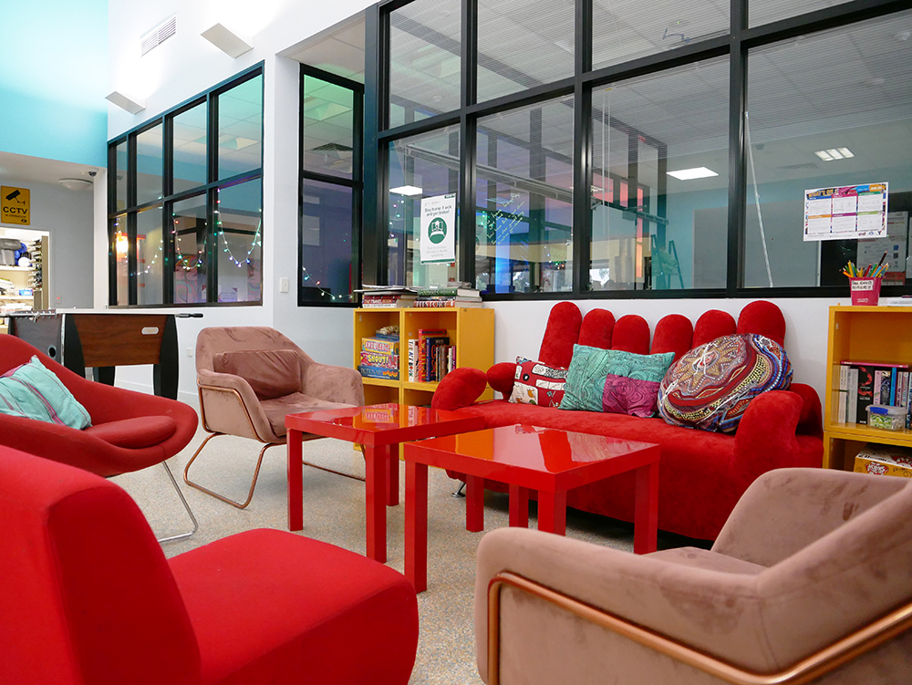 Room with couches and tables inside youth centre in Belmont
