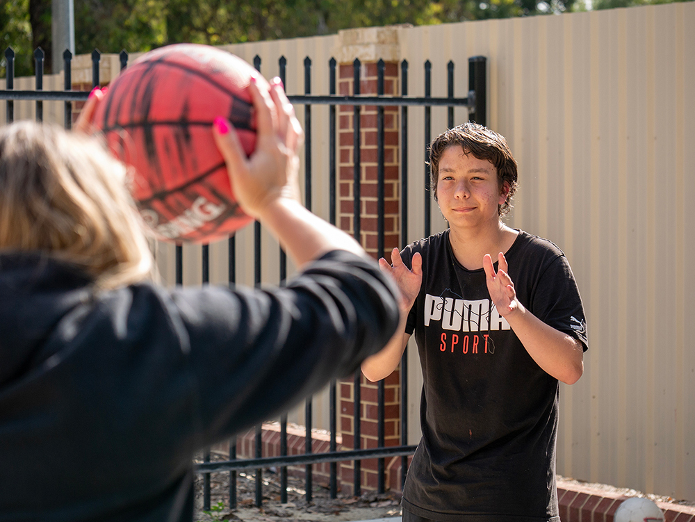 Young people playing basketball outside