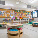 Bright early learning classroom with sensory play stations, storage cubbies, and children's artwork displays