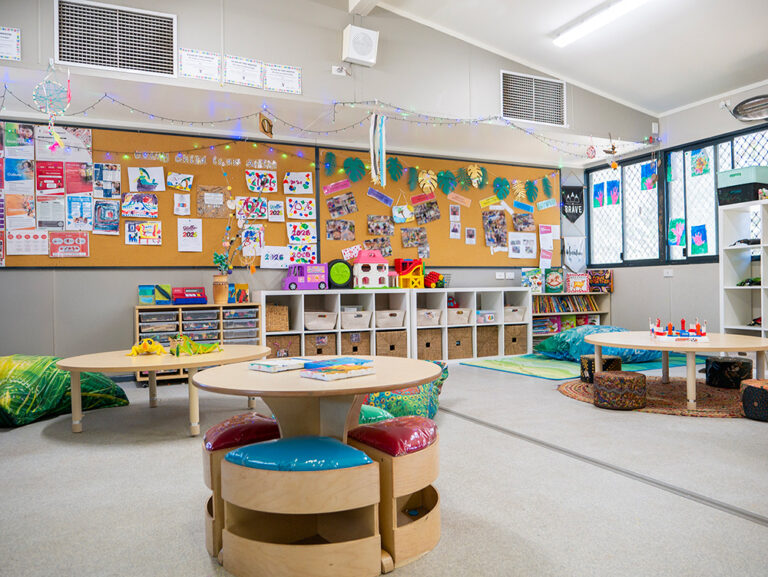 Bright early learning classroom with sensory play stations, storage cubbies, and children's artwork displays