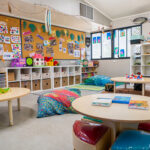 Organised early learning room with play areas, storage systems, floor cushions and educational displays