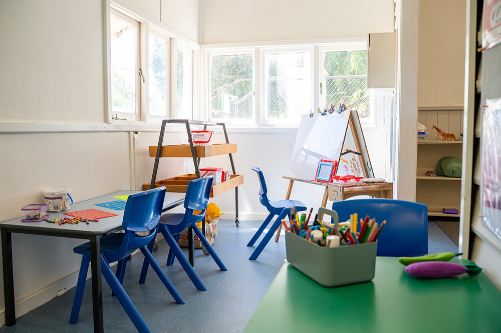 Bright OSHC art room with child-sized tables, easels, art supplies and natural window light