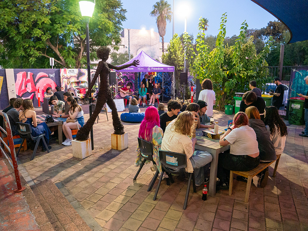 Croup of people hanging out in courtyard area during youth event at the Y HQ in Leedervile