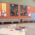 OSHC activity setup with educational posters, handprint art, benches and floor games ready