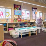 OSHC room with games storage, play tables, dollhouse and colorful window displays