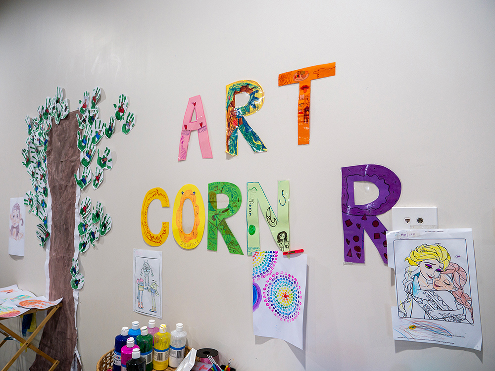 Art Corner display with decorated letters, children's artwork and craft supplies at OSHC