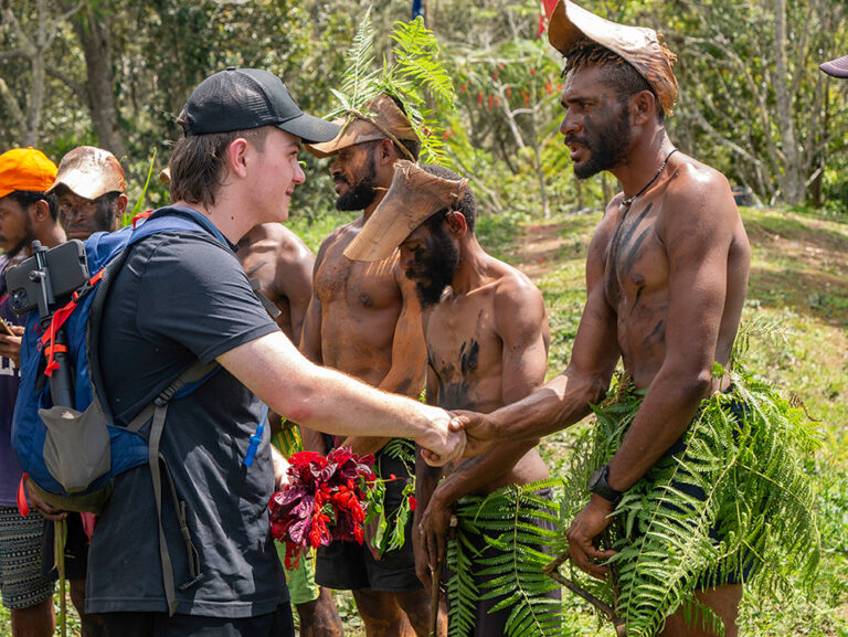 Y School student shaking hands with Papua New Guinean person on the Kokoda Trek, a program offered through the Y WA and the Y School