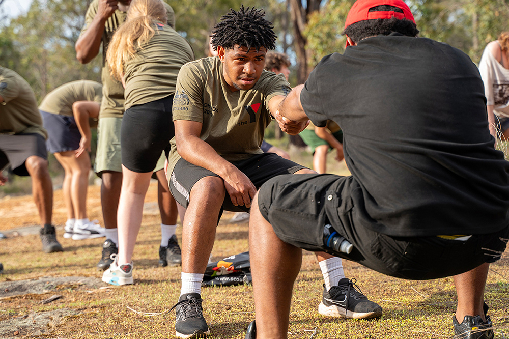 Young people in Y WA shirts participating in an outdoor physical challenge activity on the Kokoda program.