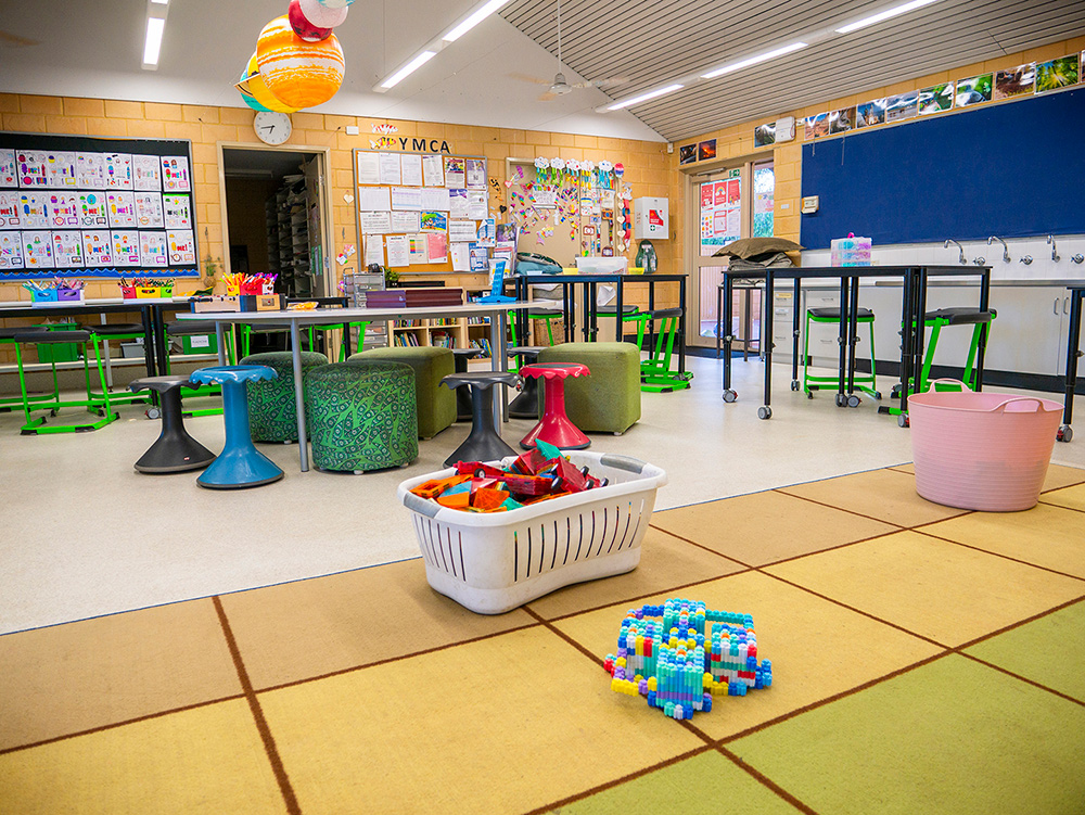 Spacious Y WA OSHC room with flexible seating, activity tables, building blocks and planet display
