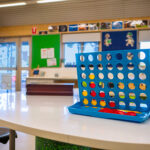 Connect Four board game set up on table in bright OSHC activity room