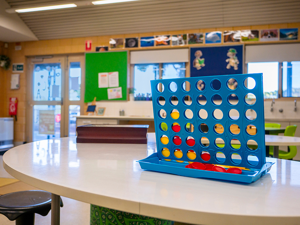 Connect Four board game set up on table in bright OSHC activity room