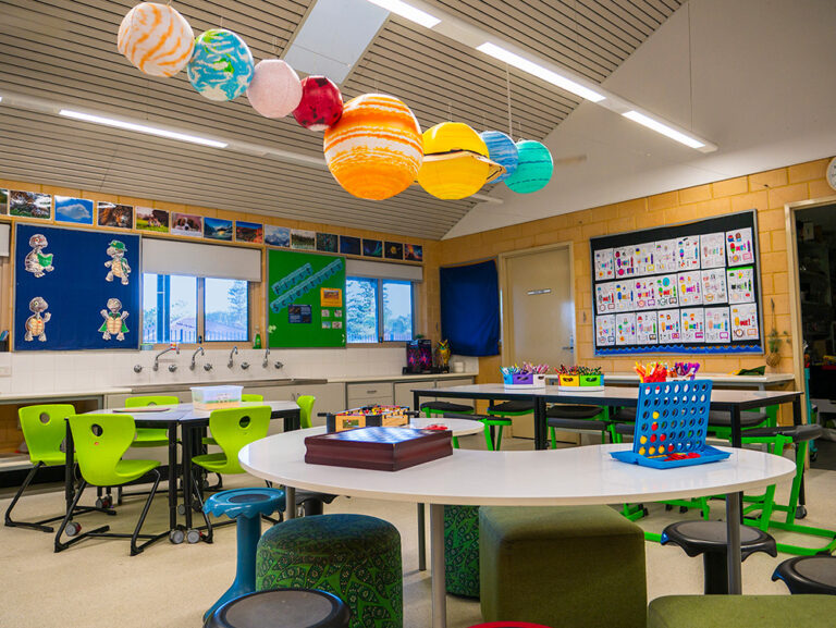 Bright OSHC classroom with solar system display hanging from ceiling and activity tables